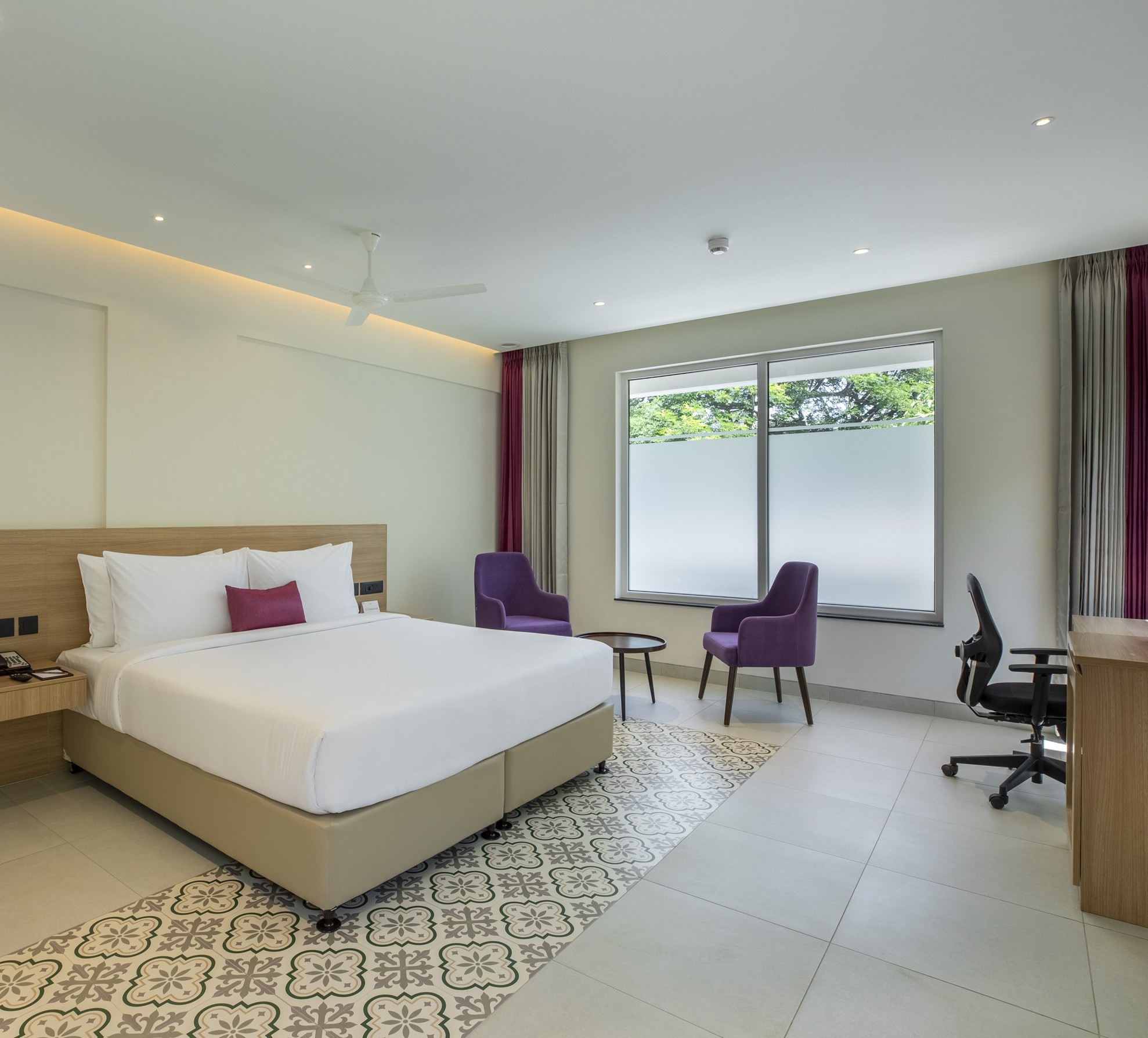 A Lilac executive room with lounge chairs and soft daylight